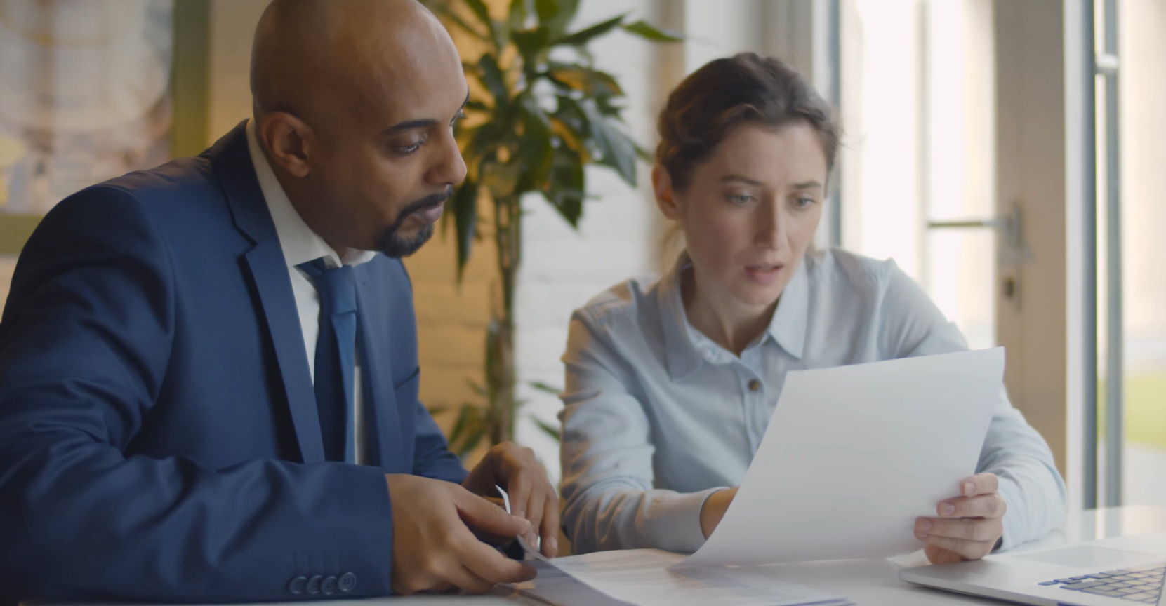 colleagues read through papers together at desk